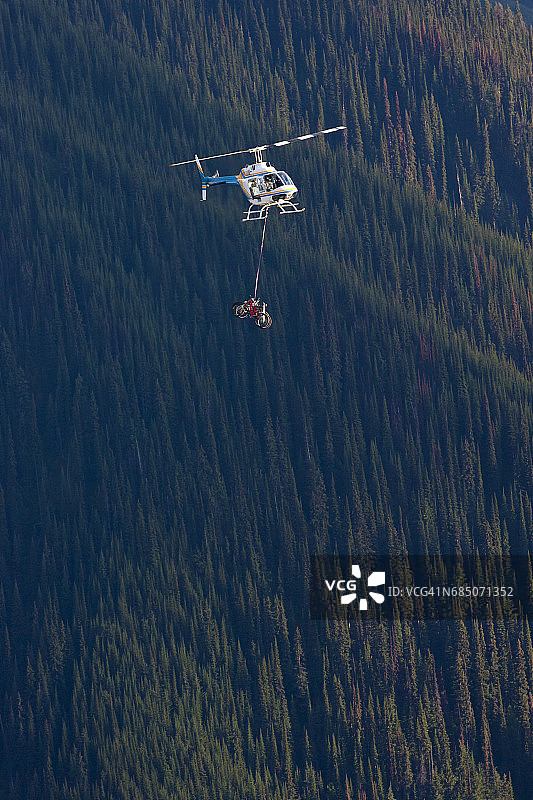 一架直升机将捆绑在一起的自行车运到加拿大不列颠哥伦比亚省的山顶图片素材
