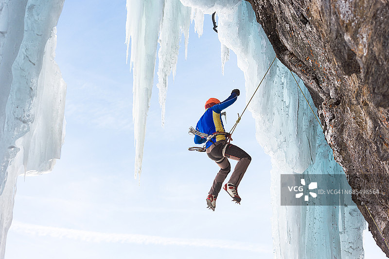 男子悬挂在安全绳上进行攀冰图片素材