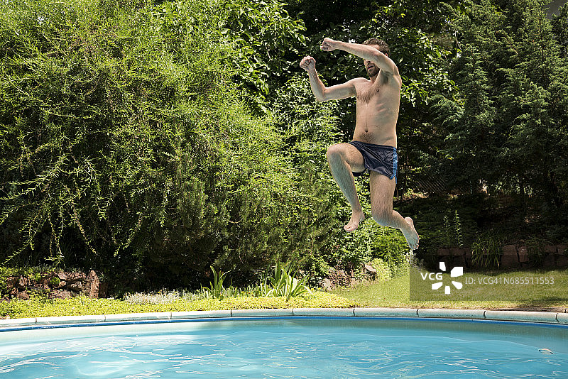 年轻男人跳入户外游泳池图片素材