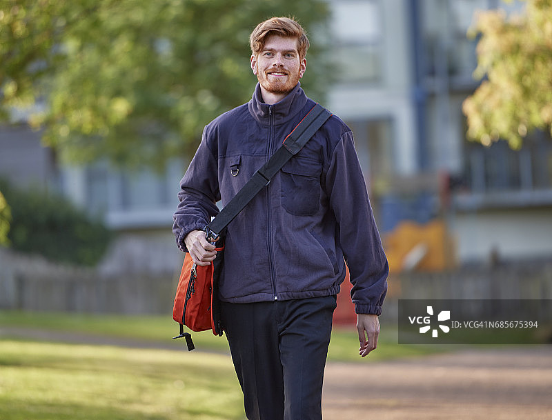 微笑，走向镜头的邮递员图片素材