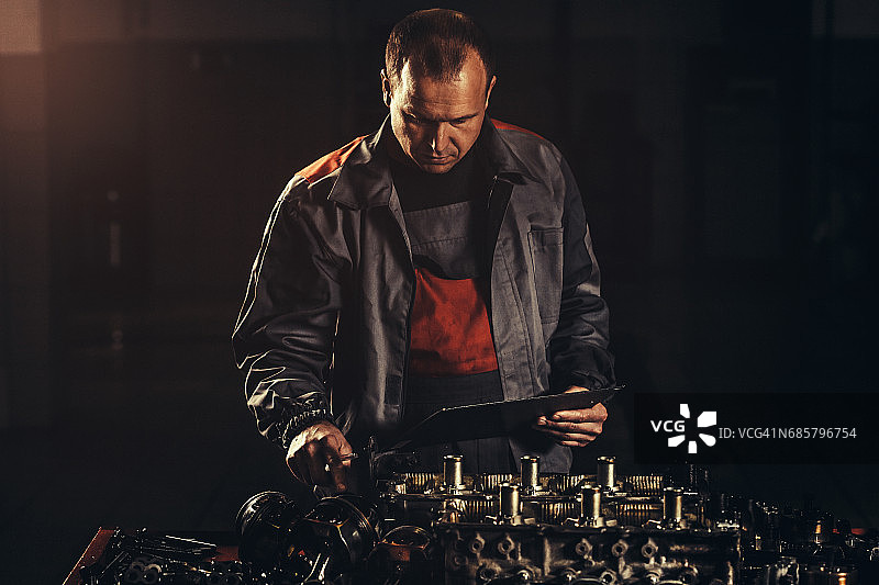 专业汽车修理工在汽车修理店修理V8发动机图片素材