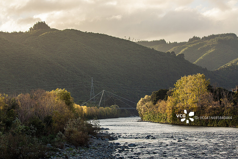 夕阳下哈特河沿岸的秋叶和人行桥图片素材