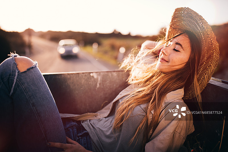 年轻女牛仔乘坐老式皮卡图片素材