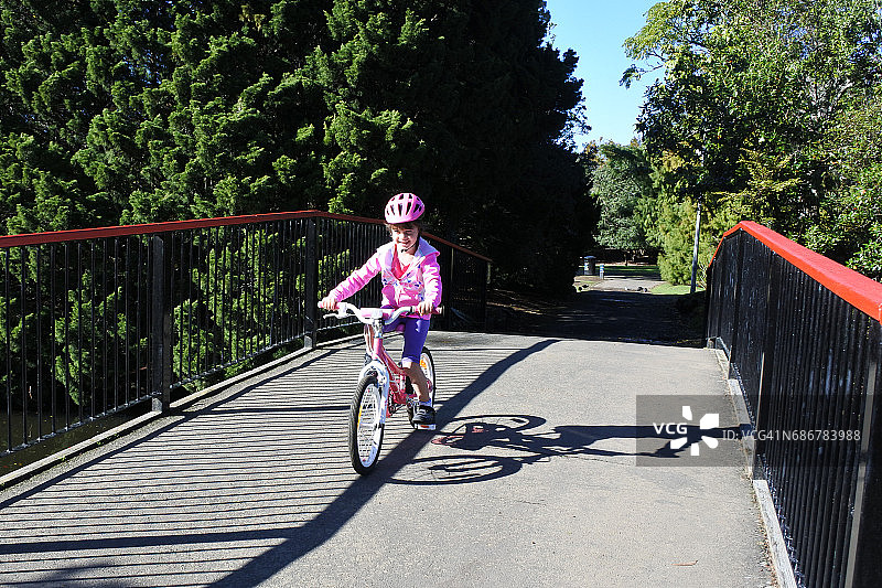 年轻女孩在公园骑自行车图片素材