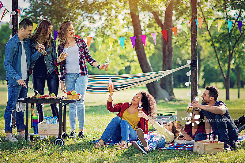 快乐的朋友们在公园里烧烤和欢呼图片素材
