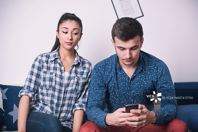 年轻女人偷看丈夫的手机图片素材