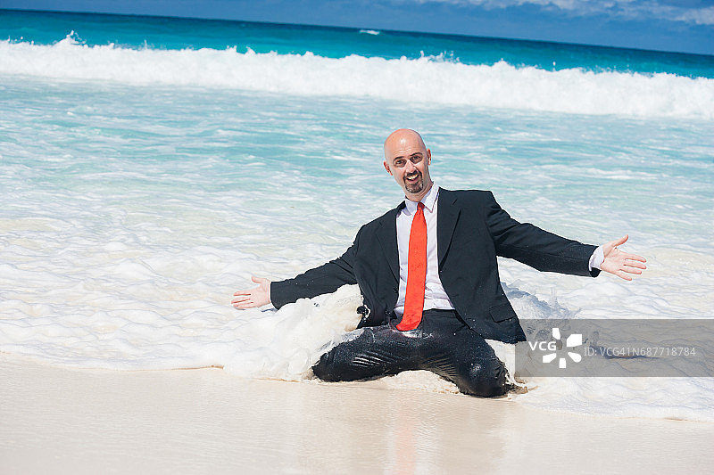 有趣的商人跪在沙滩水中图片素材