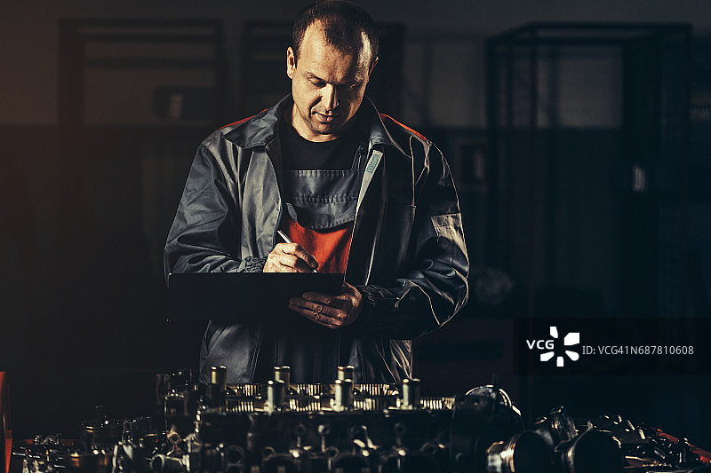 专业汽车修理工在汽车修理店修理V8发动机图片素材