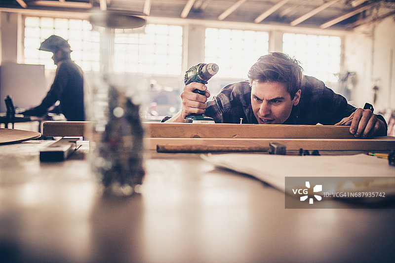 年轻修理工在车间加工木材图片素材