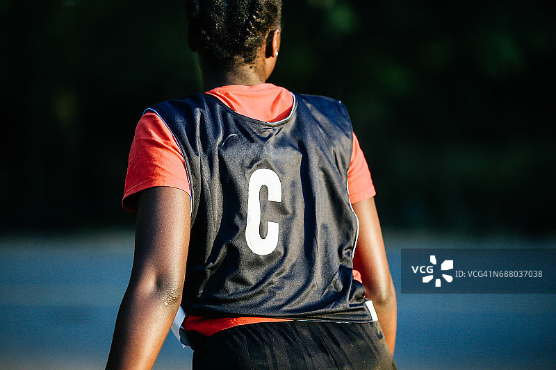 英式篮球队伍中，佩戴中心号码布的队员的背影图片素材