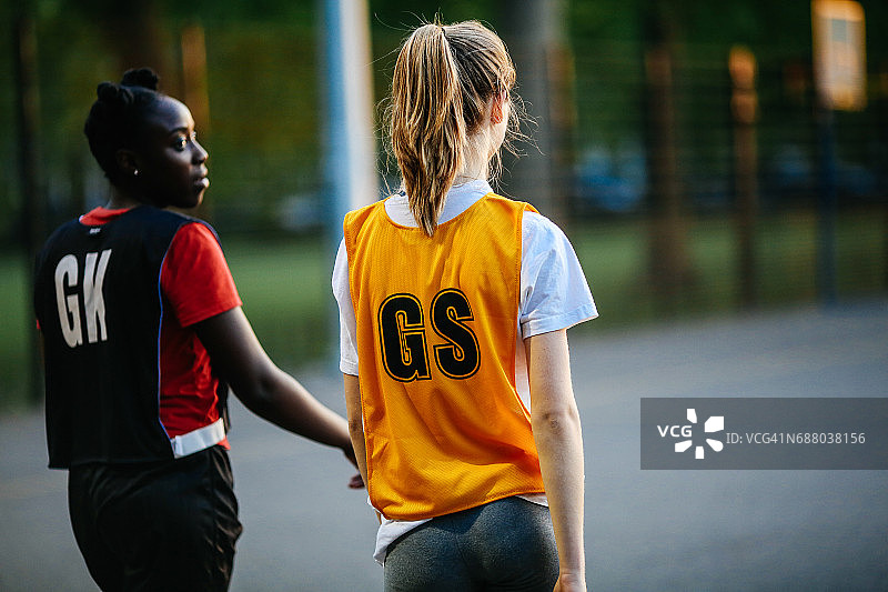 两名无板篮球运动员站在球场上的背影图片素材