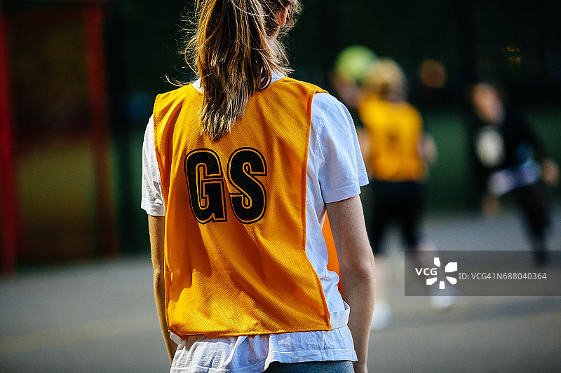 在室外篮球场比赛中站立的篮球运动员的背影图片素材