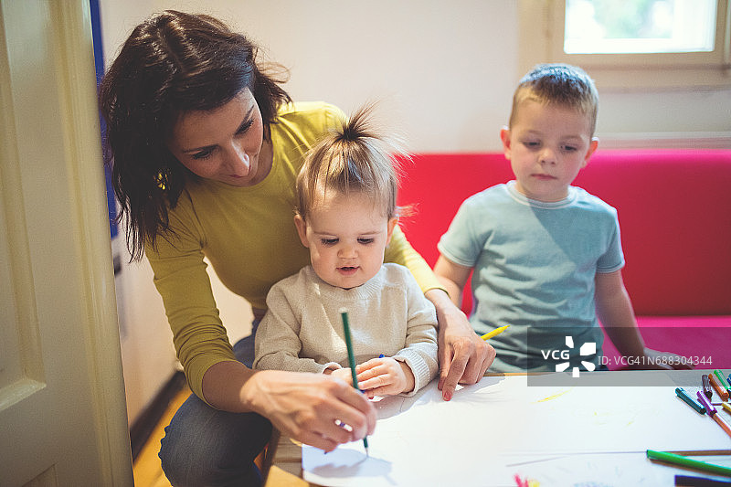 保姆和两个孩子在家画画图片素材