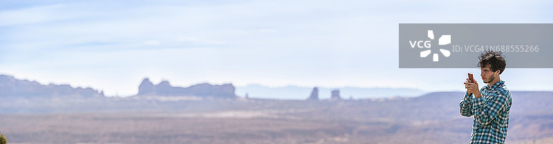 年轻旅行者在拱门国家公园盐谷用智能手机拍摄XXXL全景照片图片素材