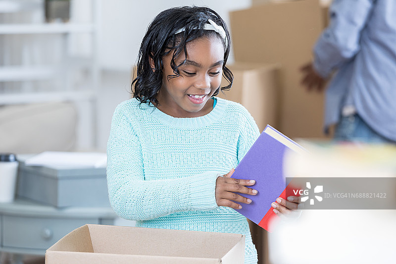非裔美国女孩在新家里打开行李图片素材