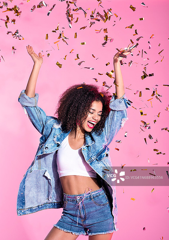 快乐的年轻非洲裔女性在五彩纸屑中图片素材