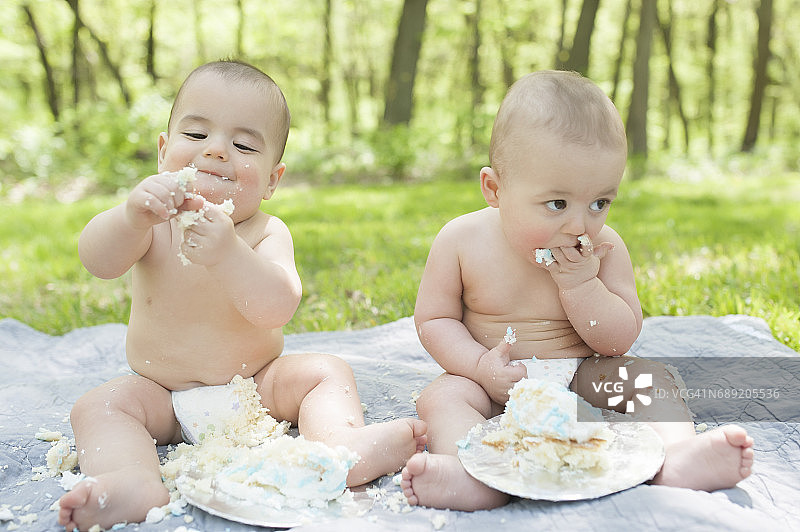 异卵双胞胎庆祝一周岁生日，蛋糕粉碎图片素材