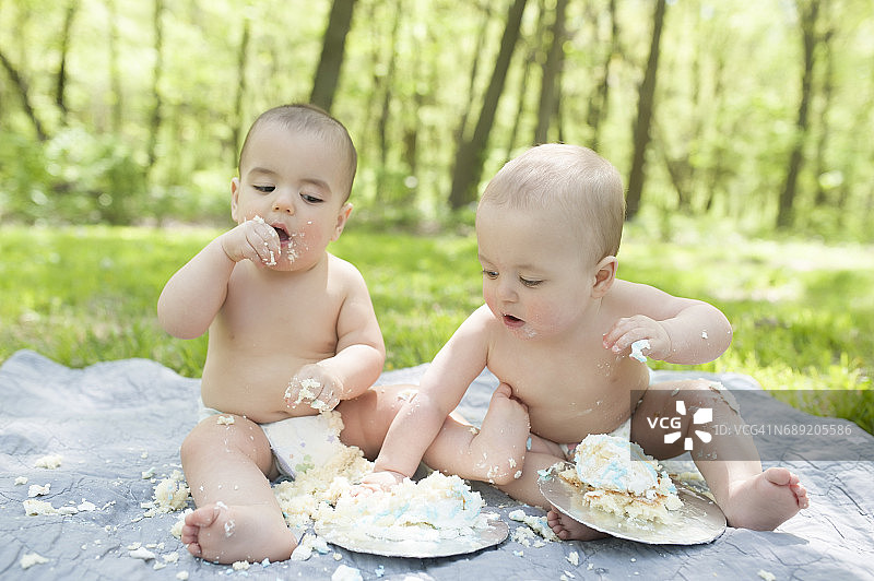 异卵双胞胎庆祝一周岁生日，蛋糕粉碎图片素材