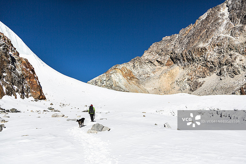 尼泊尔喜马拉雅山脉卓拉山口的徒步者和狗图片素材