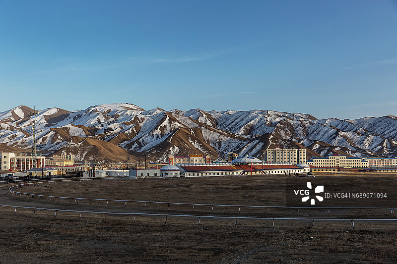 中国巴音布鲁克镇的空赛马场，背景是雪山图片素材