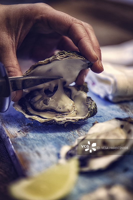 用开蚝刀打开牡蛎图片素材