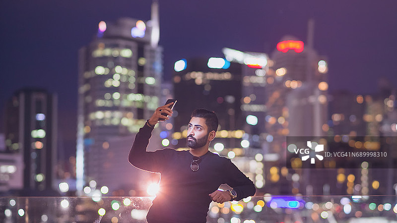 男子在城市灯光背景下自拍图片素材