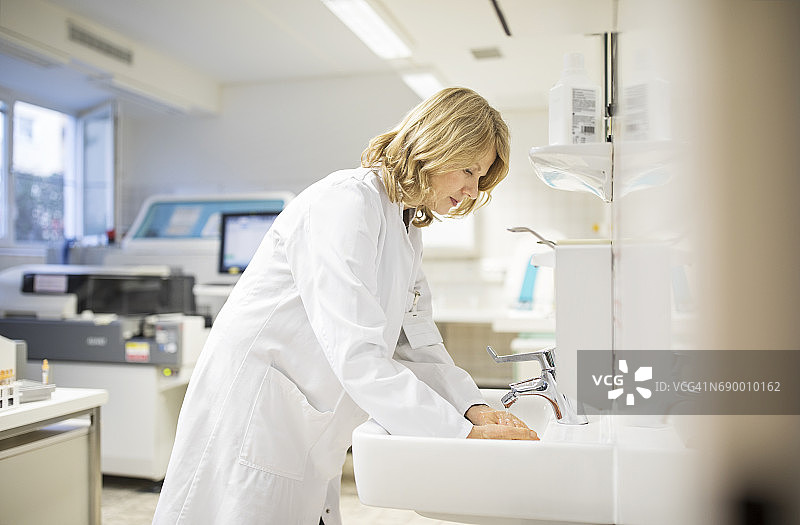 中年女科学家在水槽中洗手图片素材