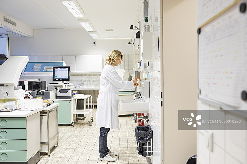 中年女医生在水槽旁分发肥皂图片素材