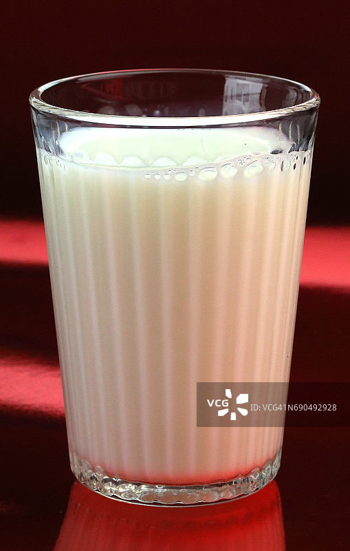 红色背景上的牛奶杯图片素材