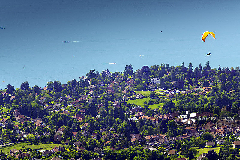 阿讷西湖高角度景观：塔卢瓦尔村与飞行中的滑翔伞图片素材