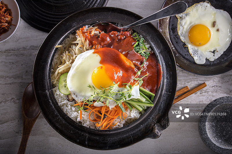 韩式石锅拌饭，拌菜饭，顶视图与热酱在铸铁锅图片素材