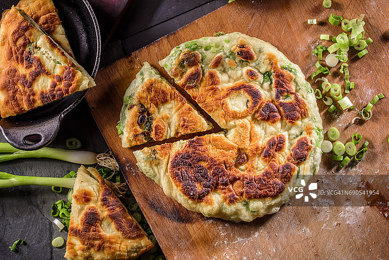 香煎葱油饼俯视图，置于砧板上图片素材