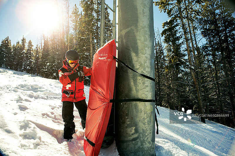在阳光明媚的一天工作的滑雪巡逻女队员图片素材