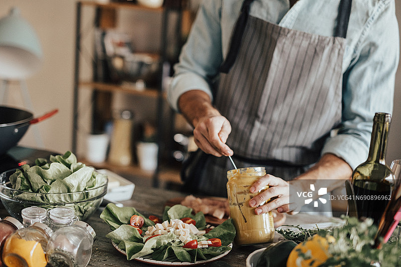 男人从罐子里取芥末的特写图片素材