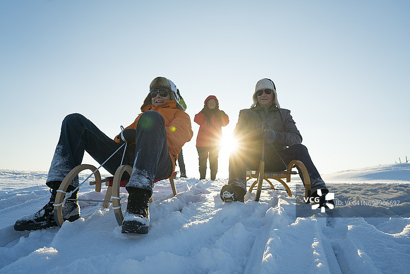 阳光老年人玩雪橇图片素材