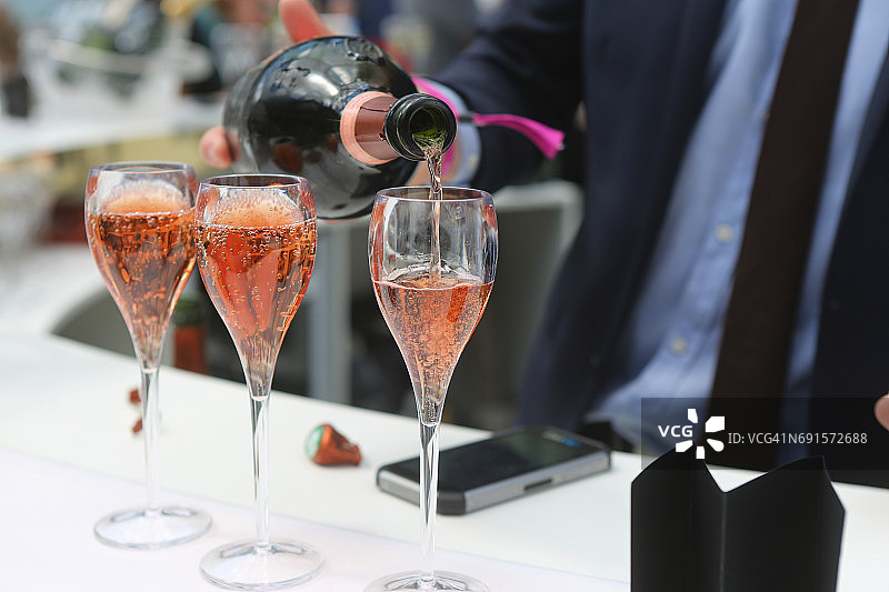 在巴黎美食节上倾倒桃红香槟图片素材