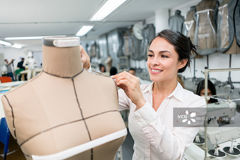 时装设计师在人体模型上进行测量图片素材