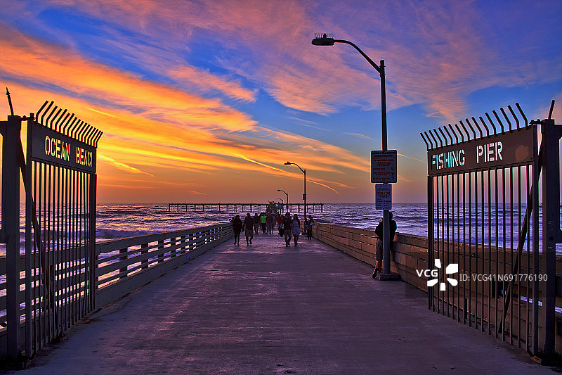 彩色日落下的海洋海滩市政码头入口图片素材