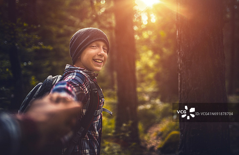 关注我。年轻男孩在徒步旅行中指路图片素材