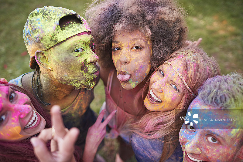 一群朋友在节日上被彩色粉末覆盖的肖像照片图片素材