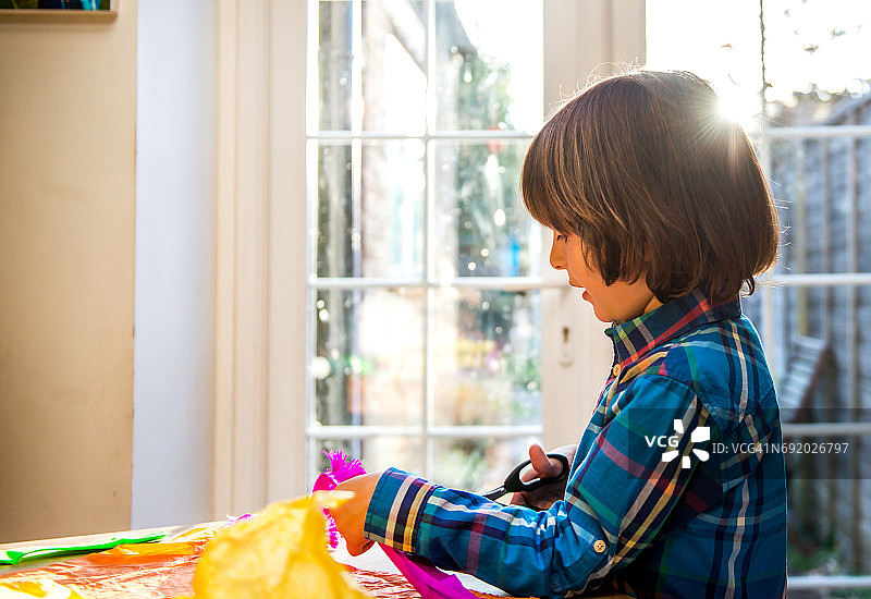 男孩剪皱纹纸制作皮纳塔图片素材