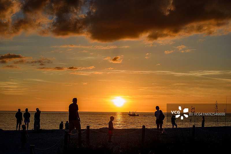 弓箭手海滩日落时分的人们剪影图片素材
