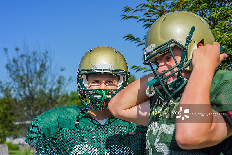 两个少年美式橄榄球运动员在球场上戴头盔图片素材