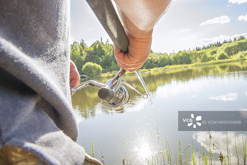 男人在水库里用钓竿钓鱼图片素材
