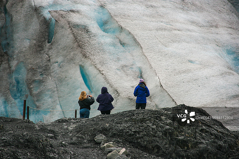 三个人在阿拉斯加欣赏出口冰川图片素材