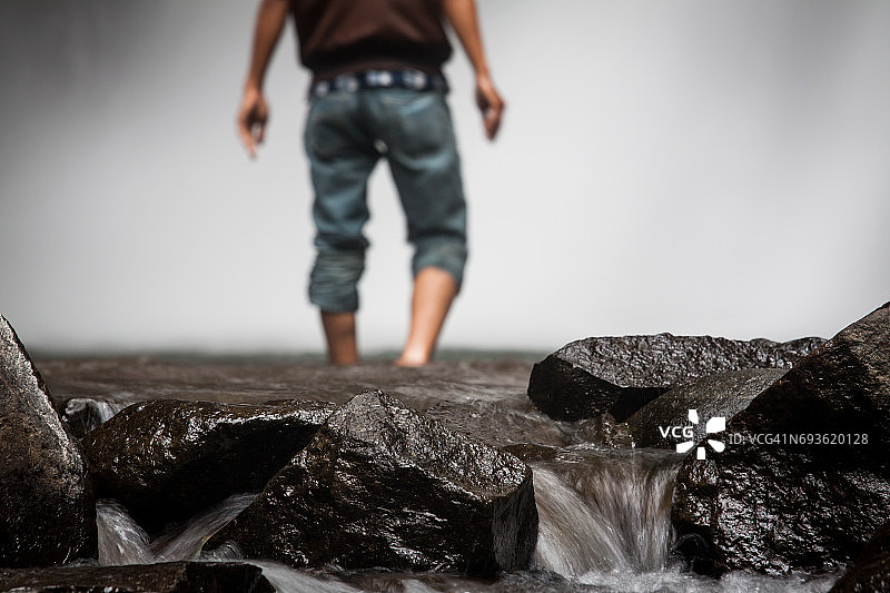 男人走向壮观的瀑布图片素材