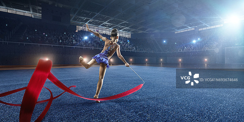 小体操女孩在大型专业舞台上用体操带进行表演图片素材