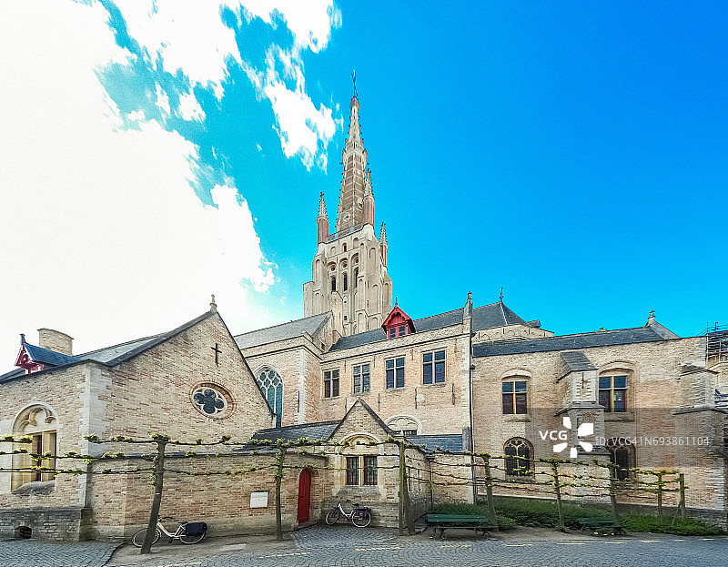 比利时弗兰德斯布鲁日的中世纪建筑和“圣母教堂”的雄伟后景，背景是砖砌钟楼图片素材