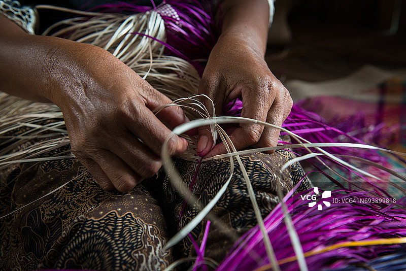 编织传统垫子的双手图片素材
