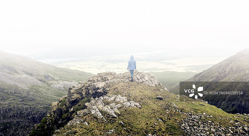孤独的徒步旅行者沉思着风景如画的山景图片素材